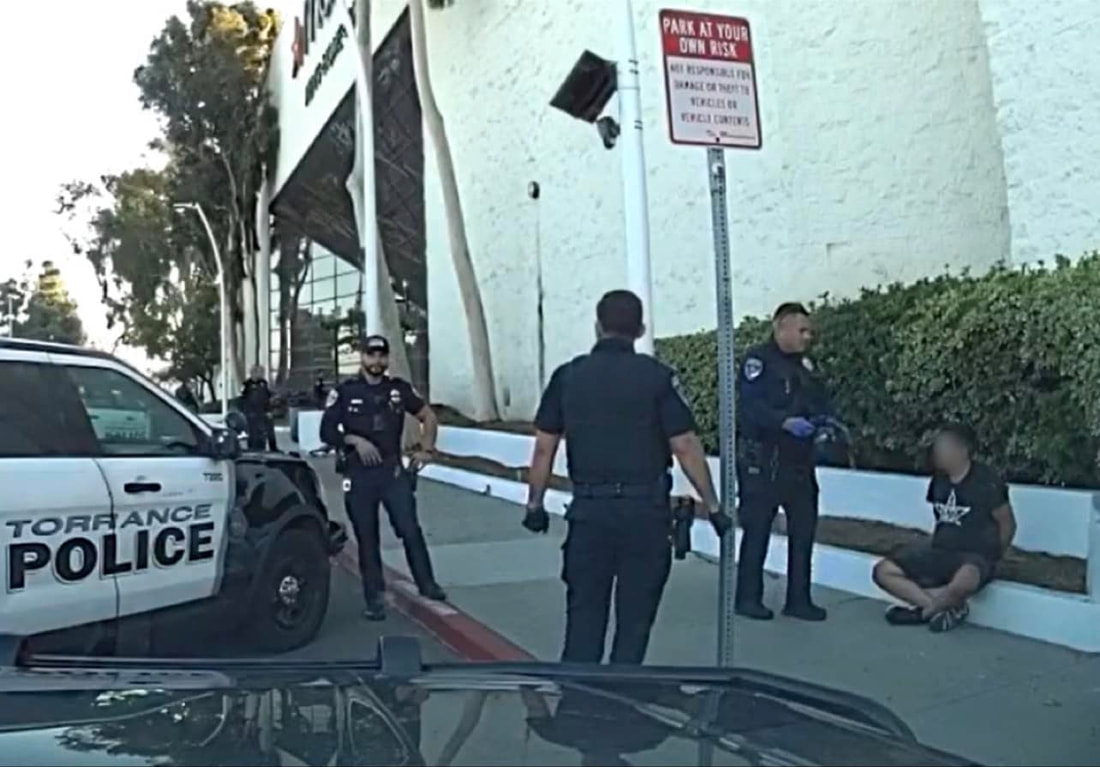 Torrance Police detaining someone sitting on a curb